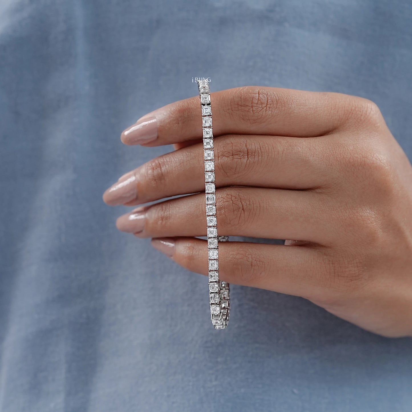 Hand holding asscher tennis bracelet with GIA certified diamond, best gift for special moment