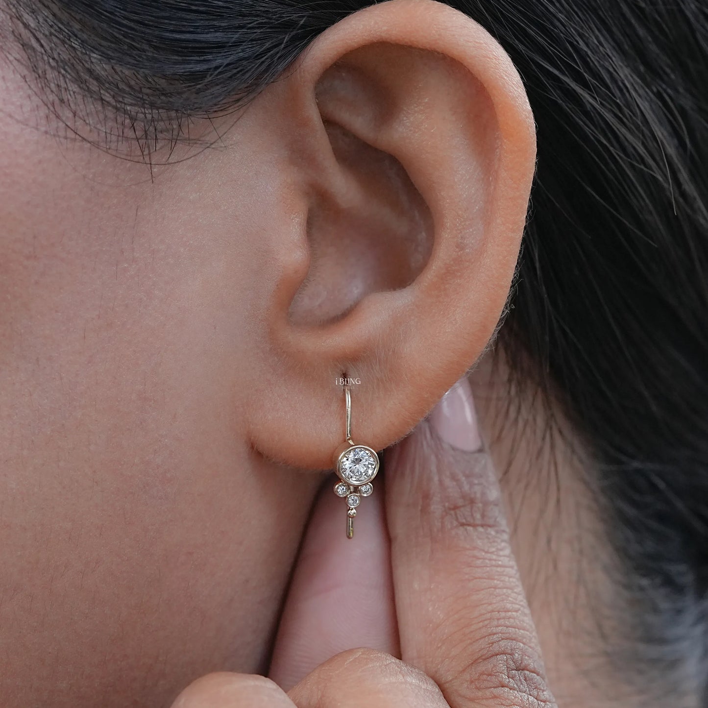 Yellow gold round diamond bezel set earring on earlobe, best luxury gift