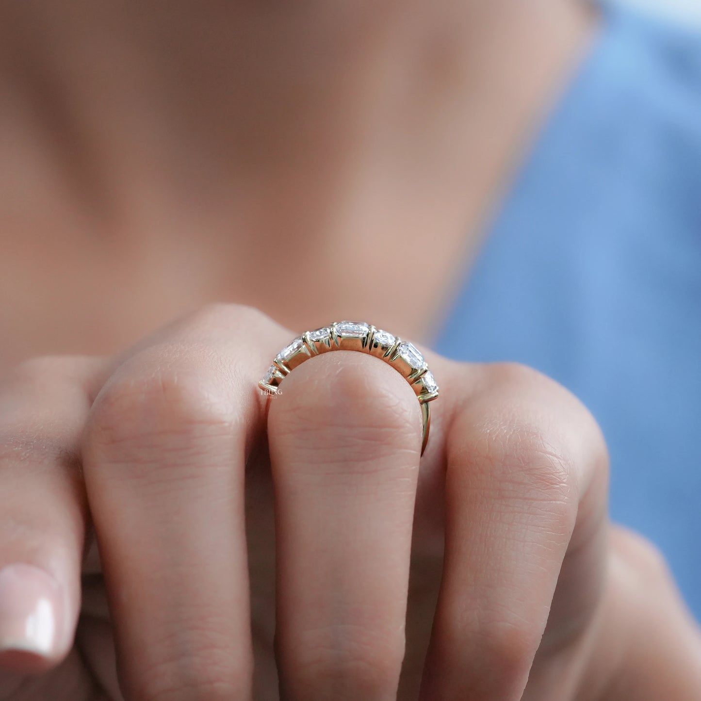 Woman wearing oval diamond wedding band with emerald cut diamond