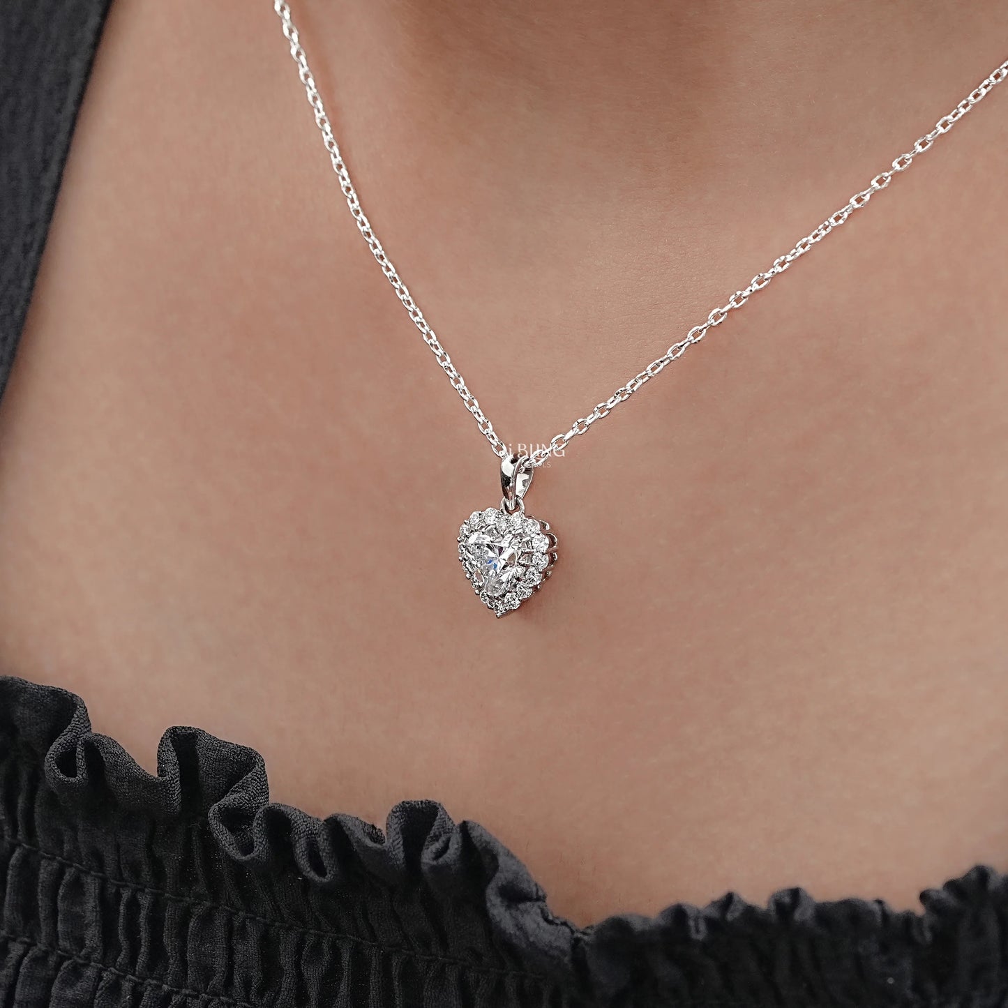 Side view diamond heart necklace silver styled with fine halo outline