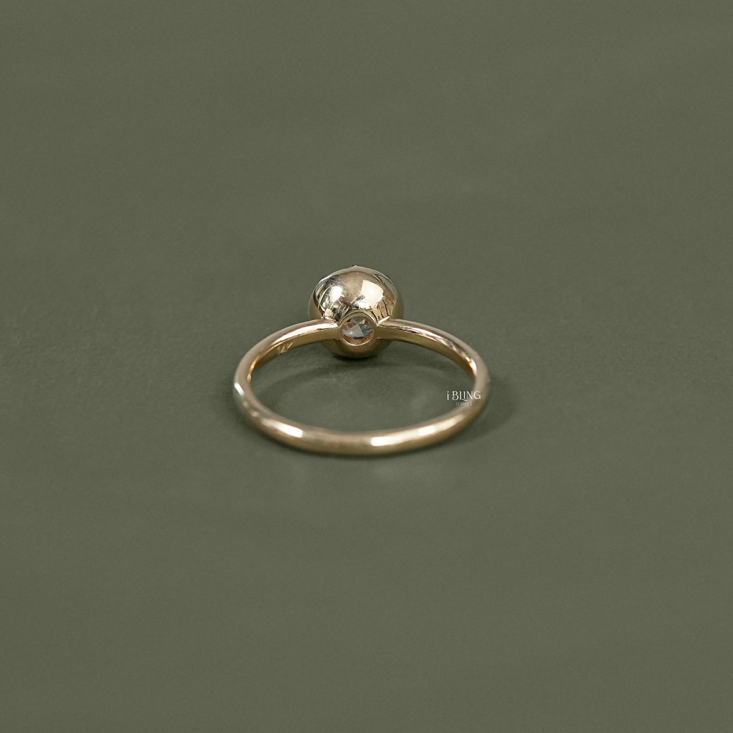 Back view of 14k gold solitaire engagement ring showing open back bezel setting