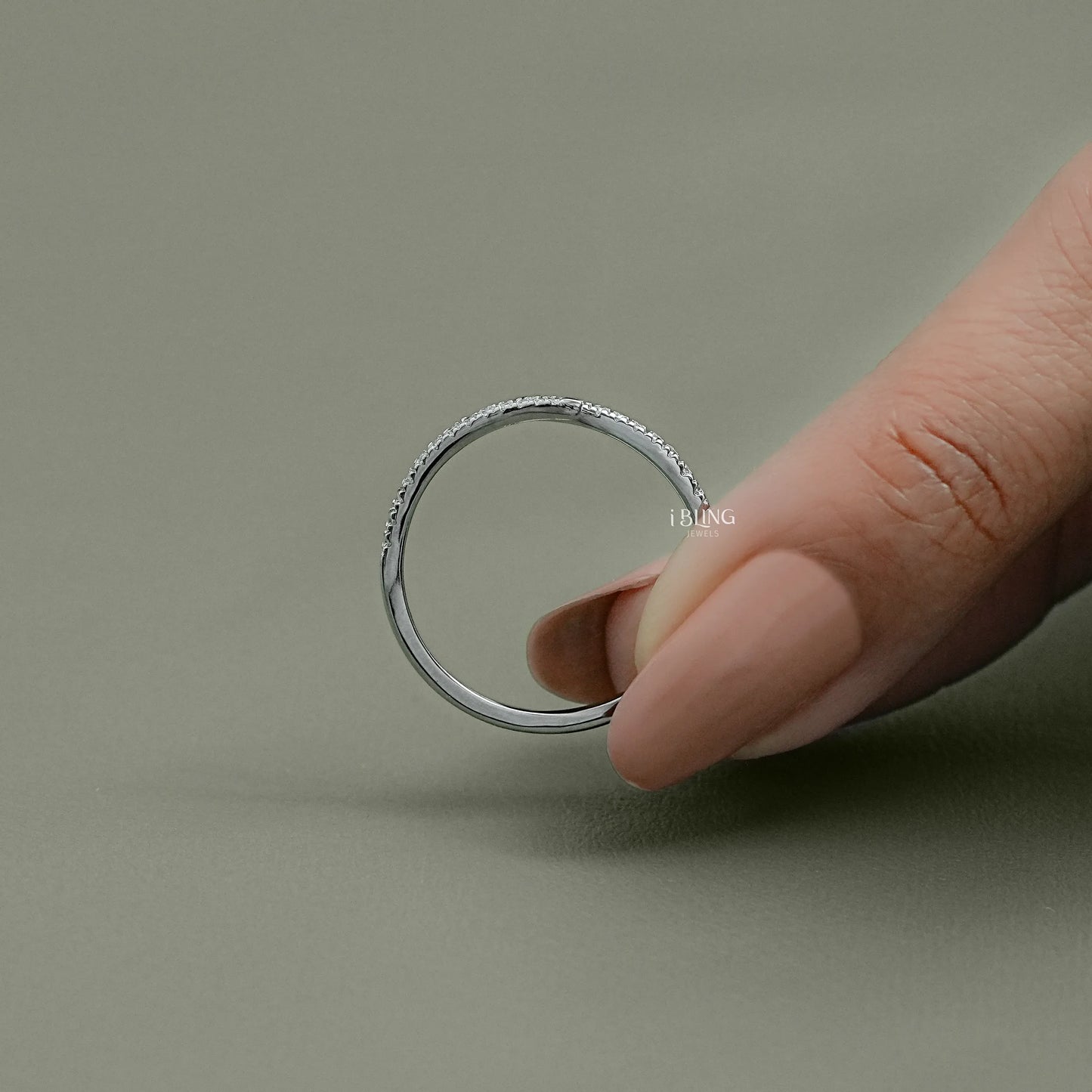 Top down view of a high-polish gold bypass ring with pave-set lab diamonds and precision cut round stones.