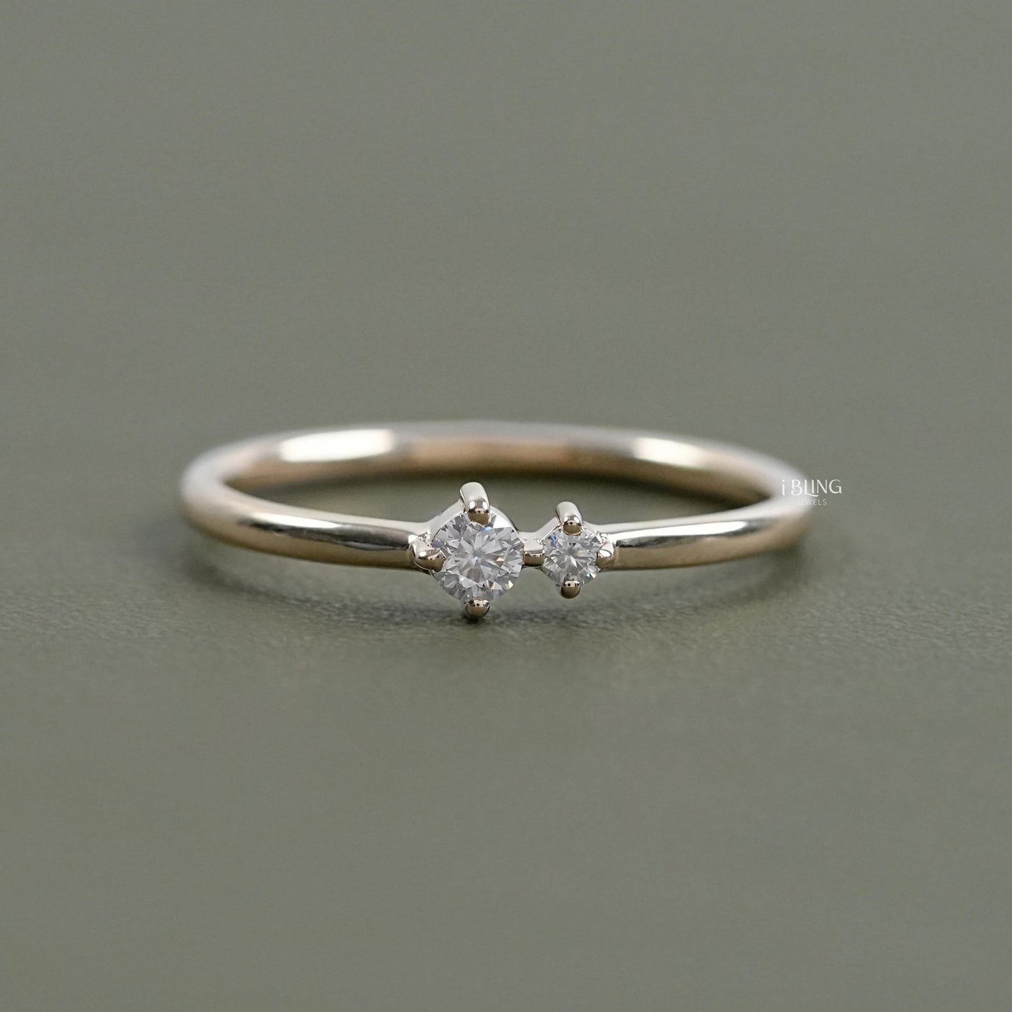 Dainty rings engagement by iBling Jewels with a round diamond and shared prong band.