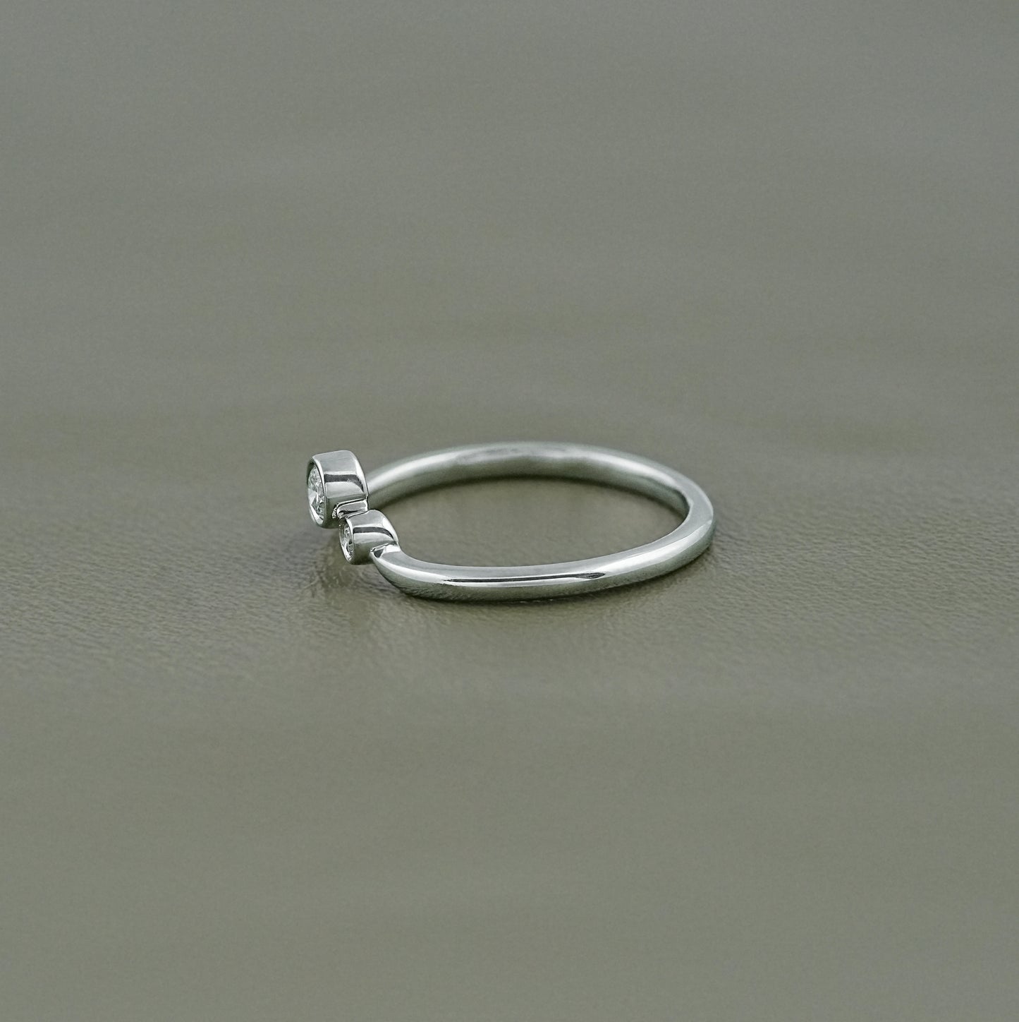 side view of a three stone diamond ring featuring secure low-profile protective bezel mounts.