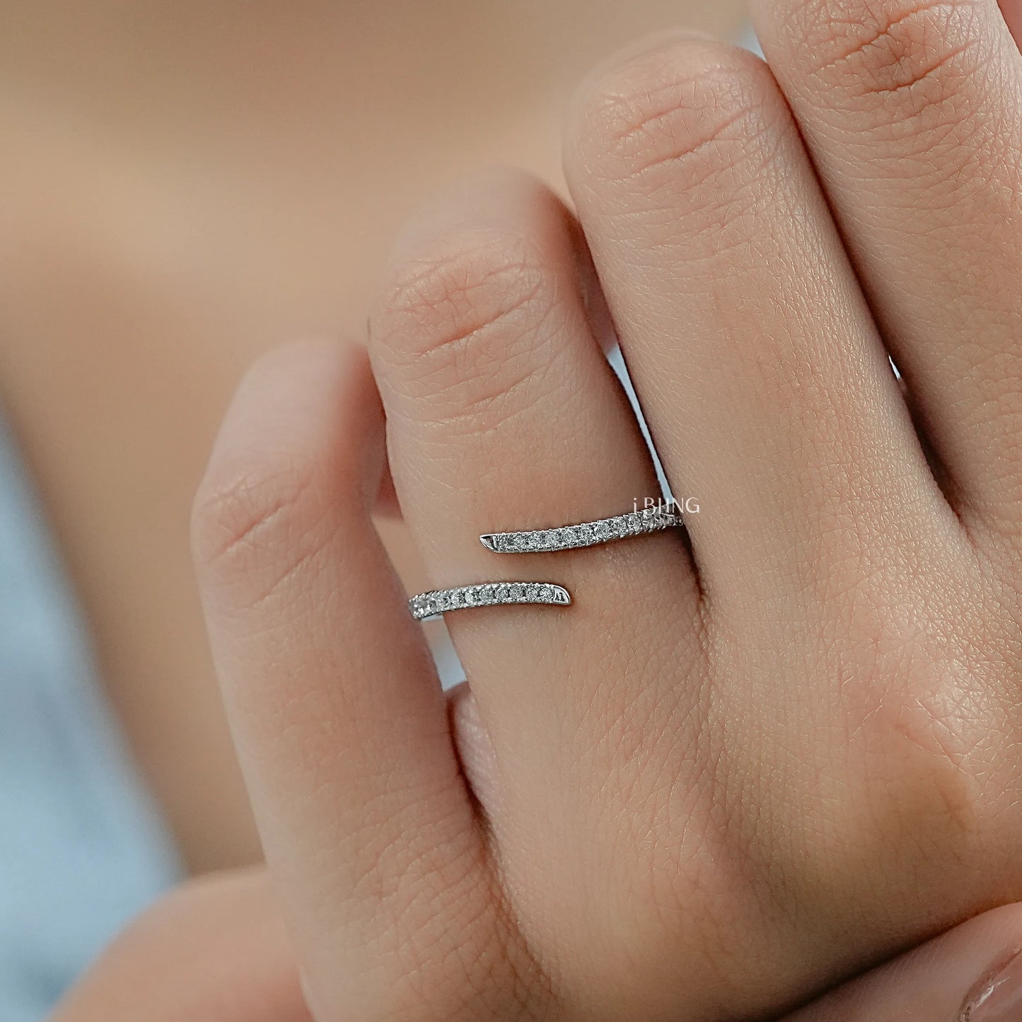Close-up of a split band bypass engagement ring held in hand to show the modern lab diamond layout.