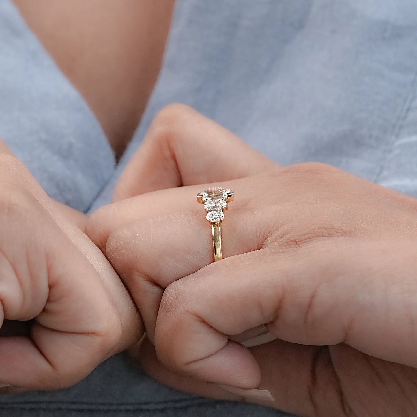Hand holding Emerald Oval Lab Grown Diamond Engagement Ring in Half Bezel Set for wedding day