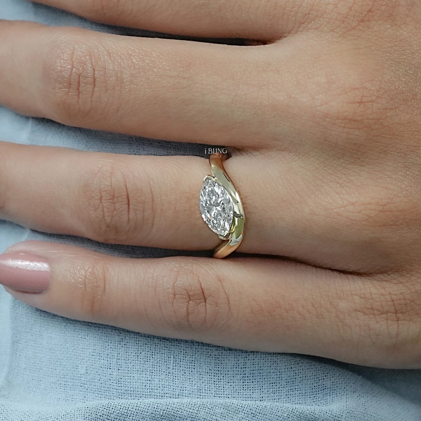 Woman hand East West Marquise ring with wedding band styled together