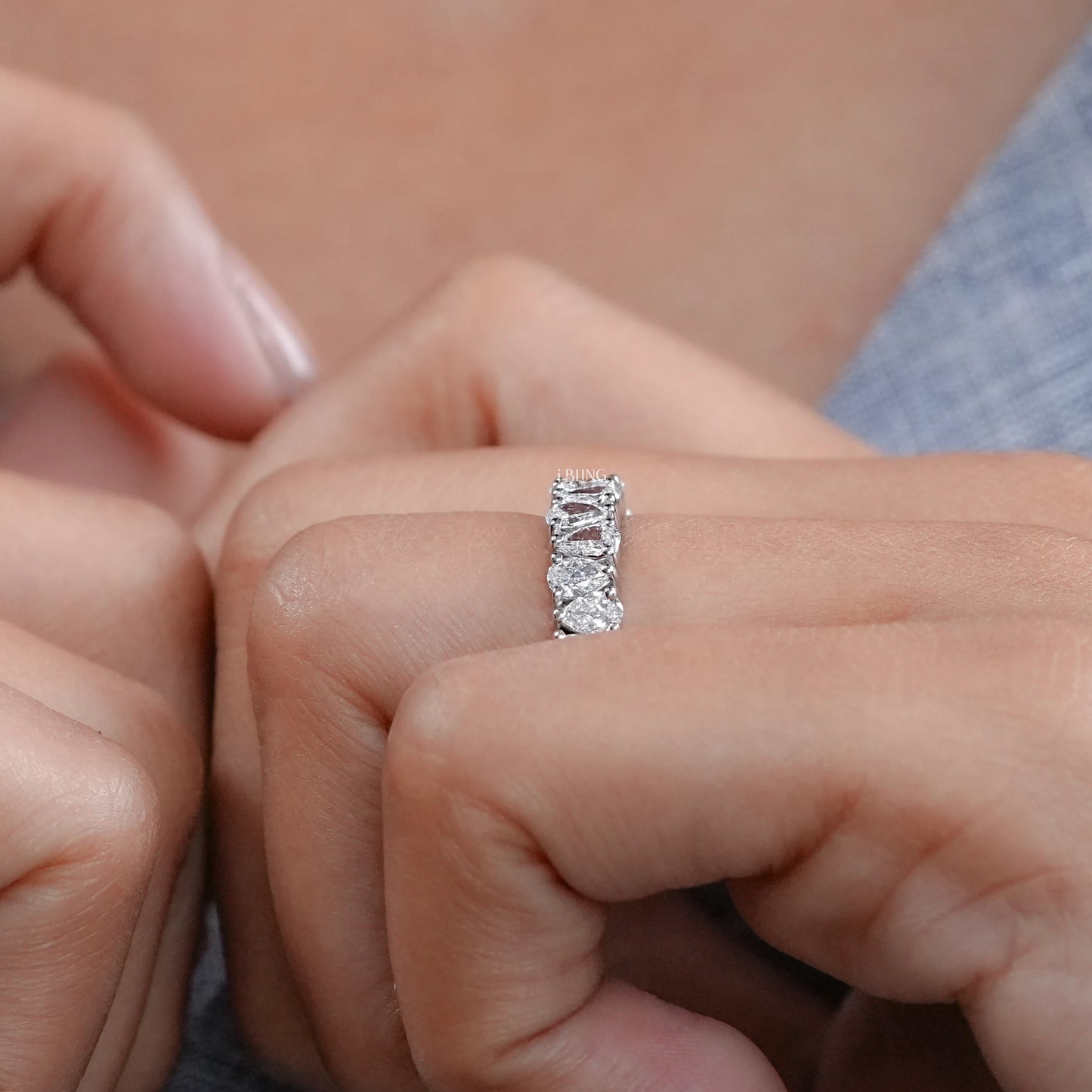 Model hand wearing Upside Down Pear Diamond Half Eternity Band, a fine lab grown diamond ring