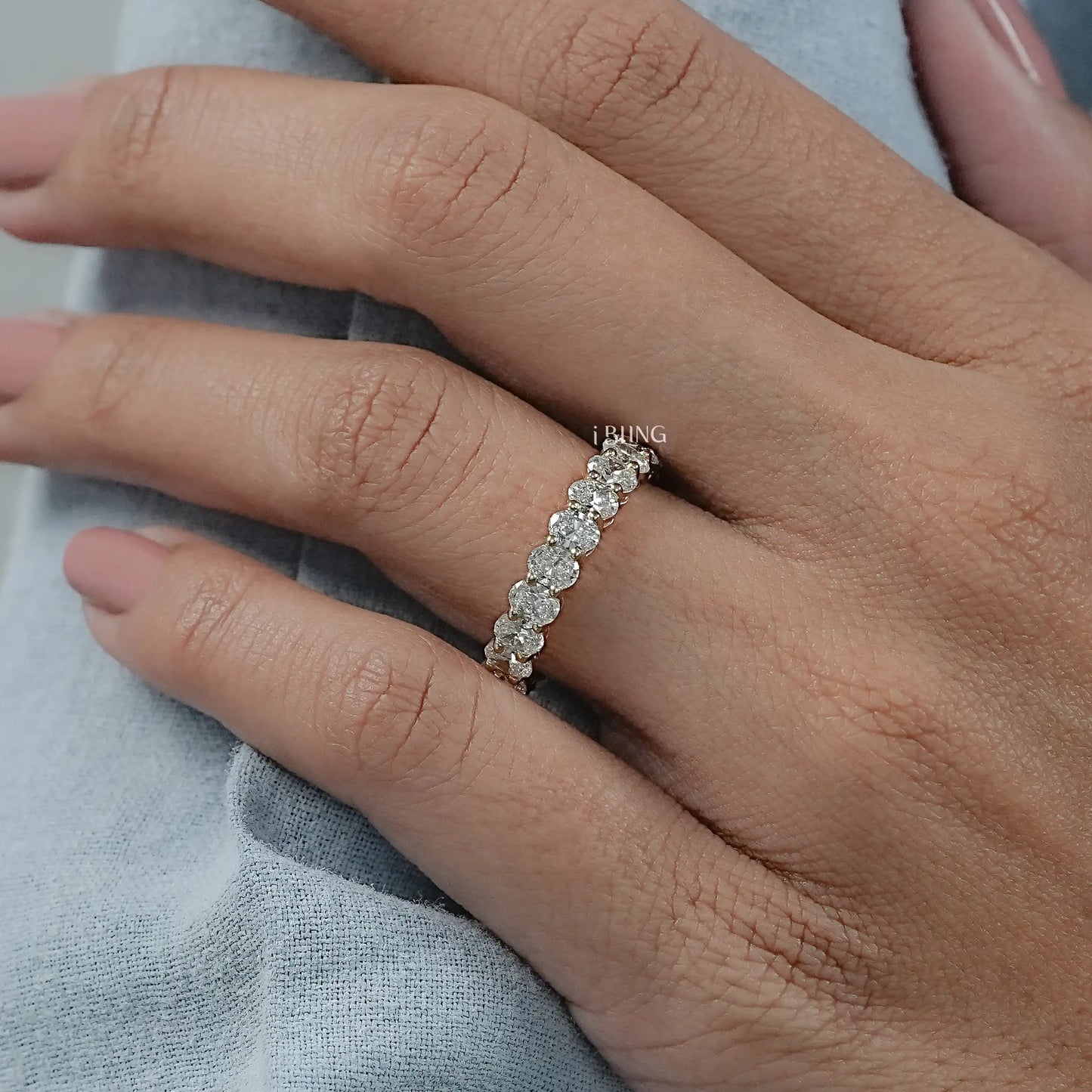 Model hand diamond wedding bands styled with oval cut stones