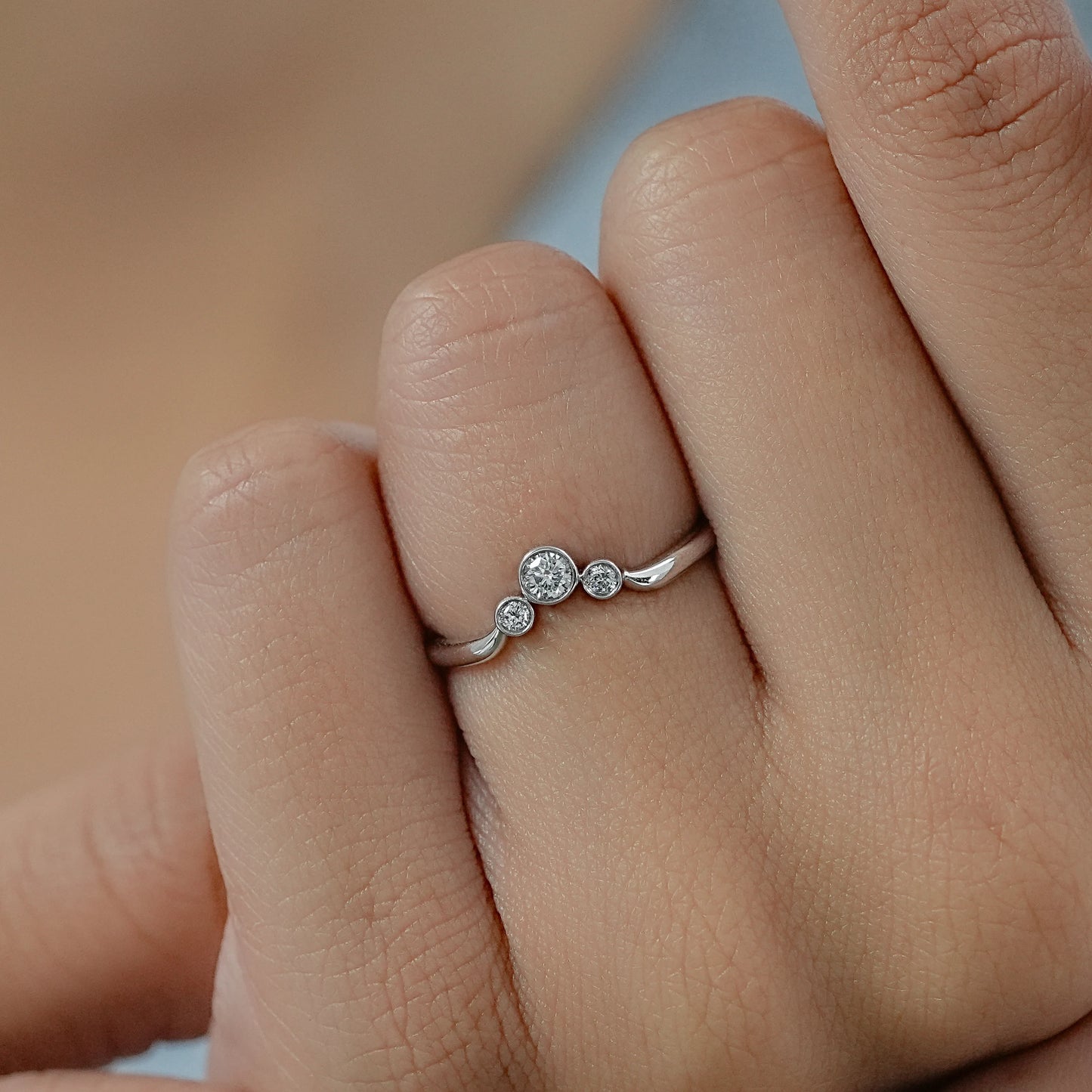 Woman hand holding a white gold curved wedding band designed to fit perfectly with engagement rings.
