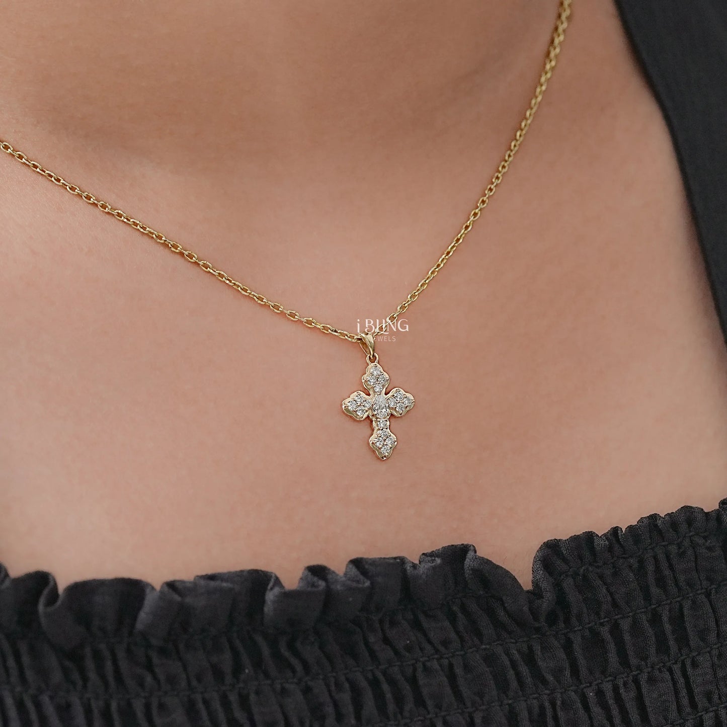 Model neck cross diamond pendant featuring pear cut lab grown diamond