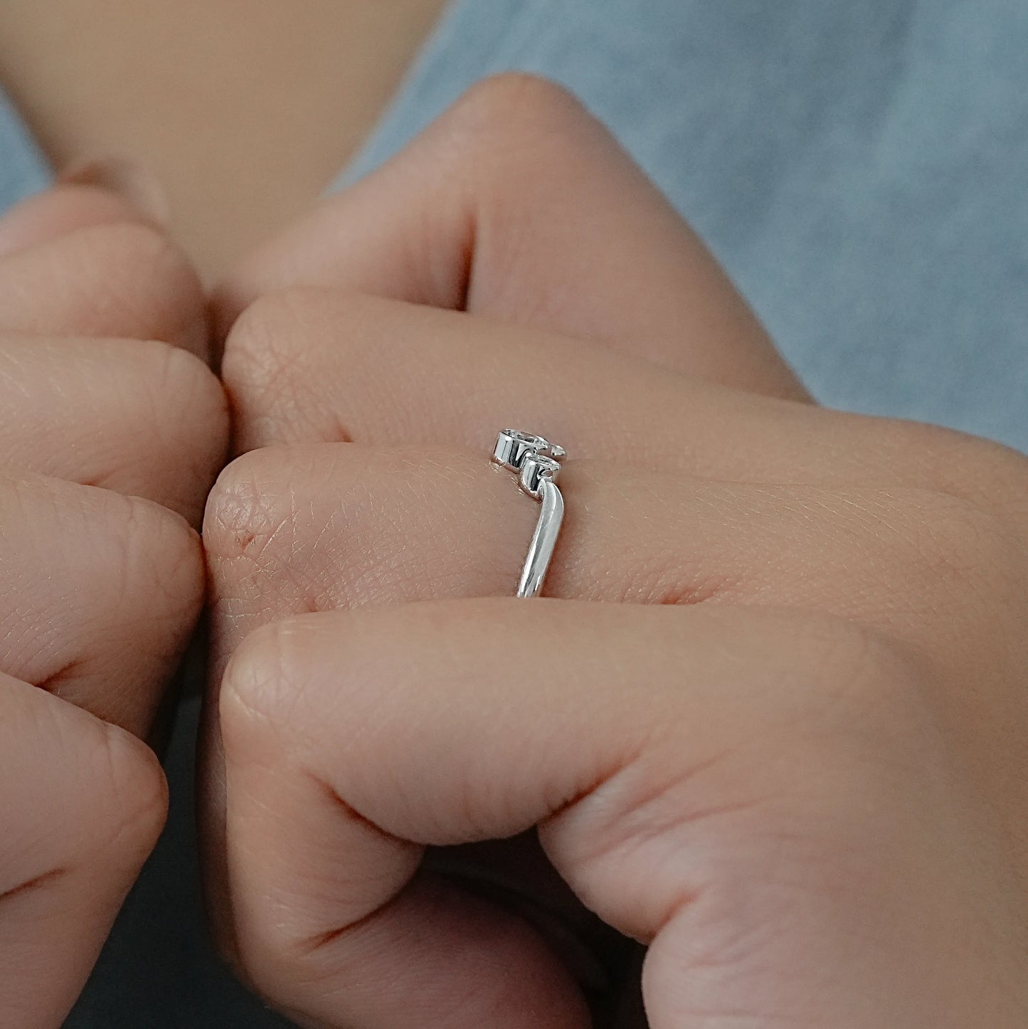 Model styling a curved wedding band white gold for a modern stacked ring look.