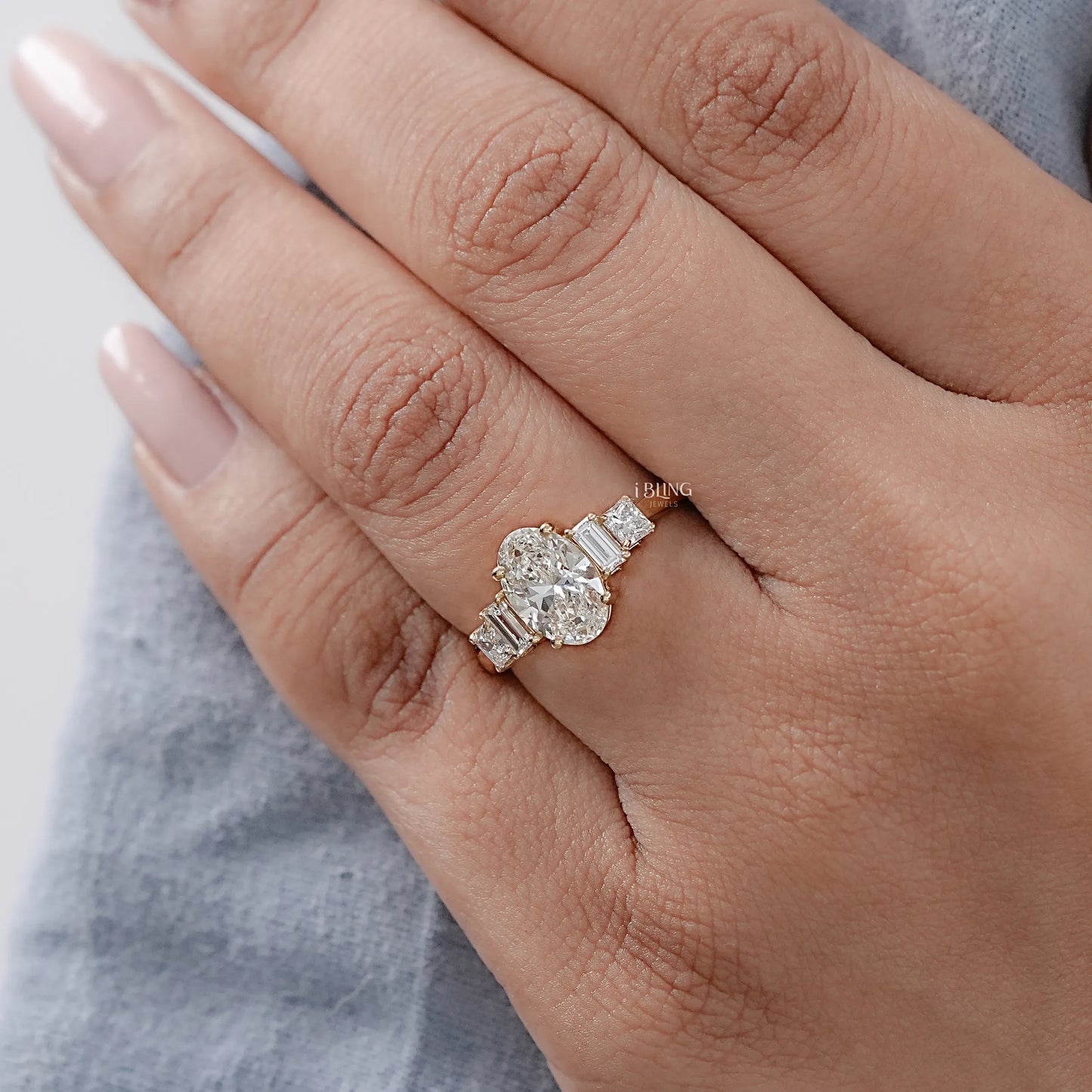 Woman hand wearing Oval Princess Cuts Diamond Engagement Ring with Baguette Wedding Band
