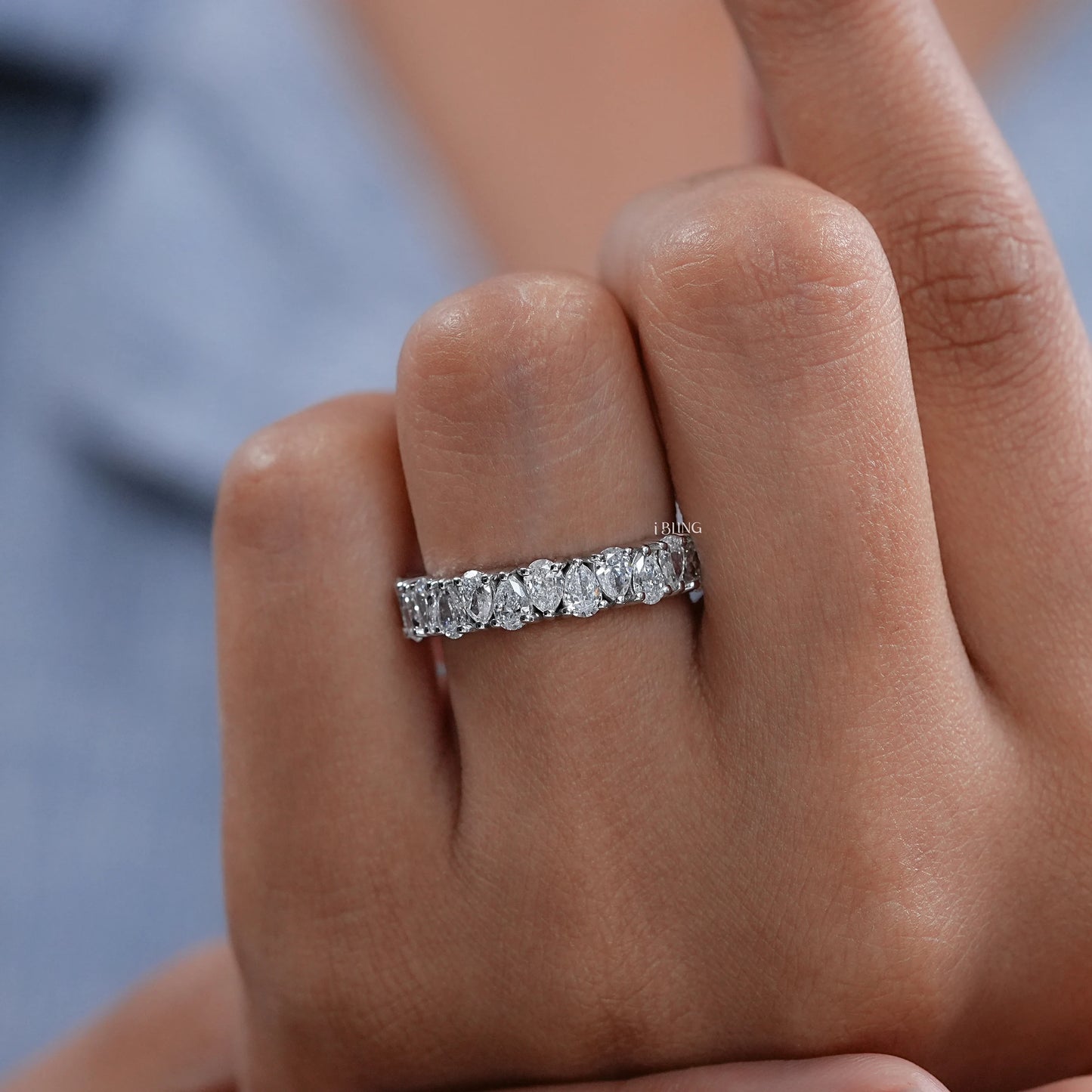 Woman hand wearing Pear Shape Upside Down Diamond Half Eternity Band, ideal engagement jewelry