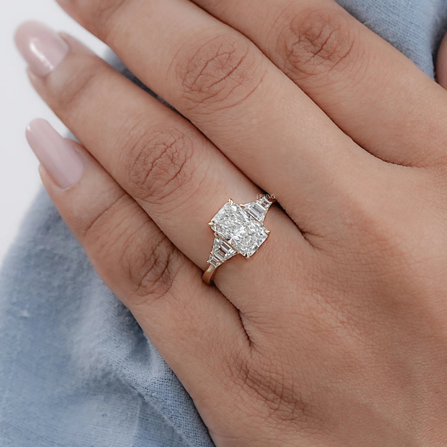 Woman hand wearing Radiant Cut Diamond Engagement Ring with Trapezoid side stones