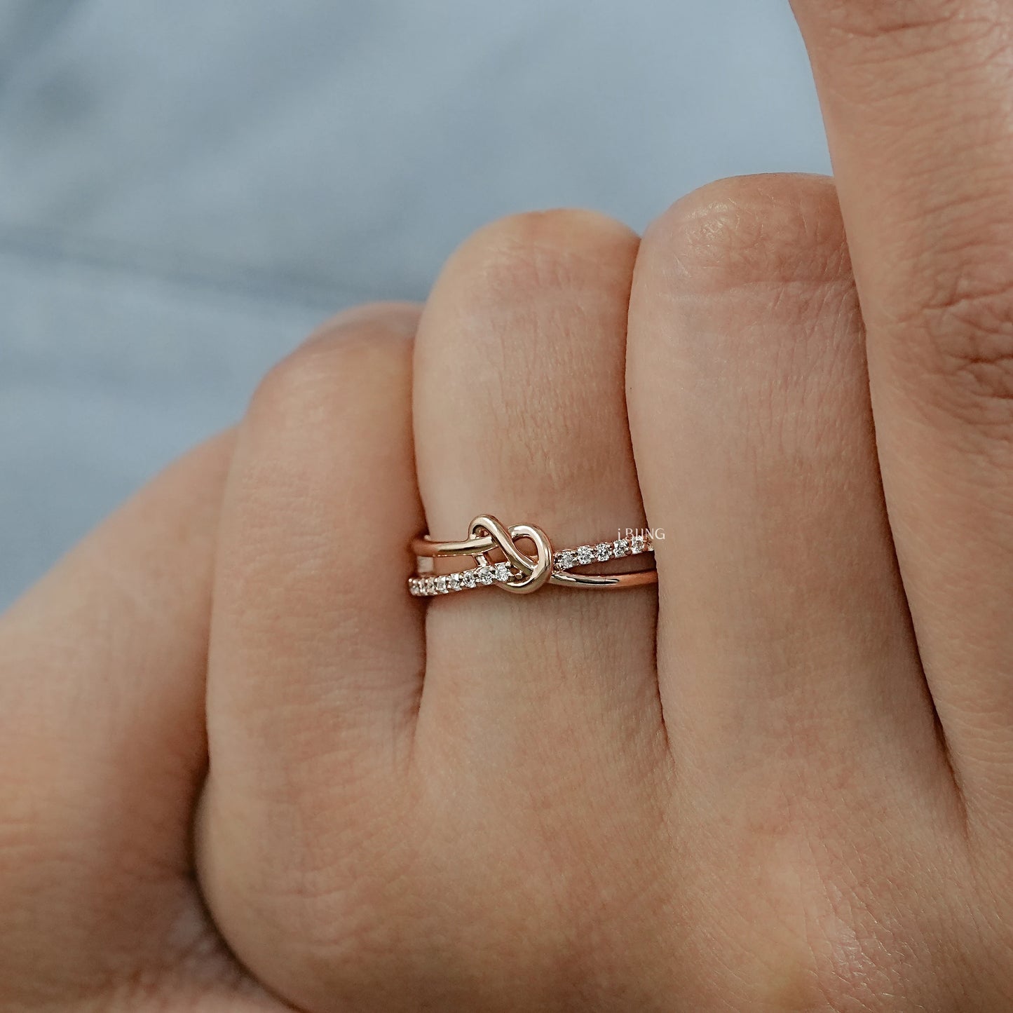 Woman hand celtic knot wedding bands crafted in round diamond style