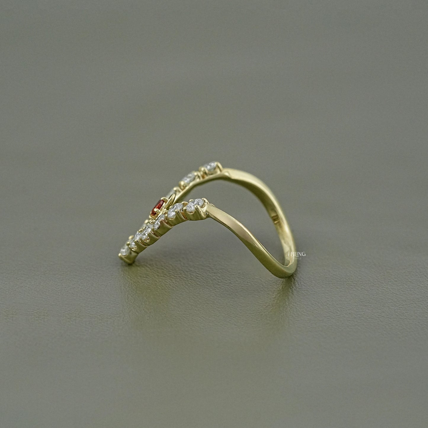 Unique v shaped engagement ring with a crown-like appearance featuring lab diamonds and ruby.